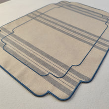 Cargar imagen en el visor de la galería, Mantel individual resinado, tela estilo saco francés, en rayas azules sobre fondo crudo, y acabado bordado en color azul.