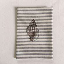 Cargar imagen en el visor de la galería, Servilleta de algodón con rayas azules sobre fondo crudo, con un estilo muy marinero. El bordado es de concha marina realizado con hilo de color marrón
