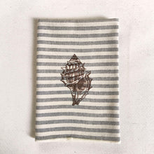 Cargar imagen en el visor de la galería, Servilleta de algodón con rayas azules sobre fondo crudo, con un estilo muy marinero. El bordado es de concha marina realizado con hilo de color marrón
