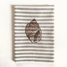 Cargar imagen en el visor de la galería, Servilleta de algodón con rayas azules sobre fondo crudo, con un estilo muy marinero. El bordado es de concha marina realizado con hilo de color marrón
