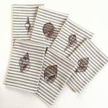 Cargar imagen en el visor de la galería, Conjunto seis servilletas de algodón con rayas azules sobre fondo crudo, con un estilo muy marinero. Los bordados son de conchas realizado con hilo de color marrón
